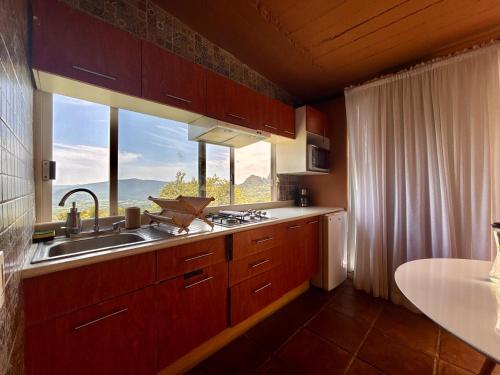 a kitchen with a sink and a large window at Amara Tepoztlán in Tepoztlán