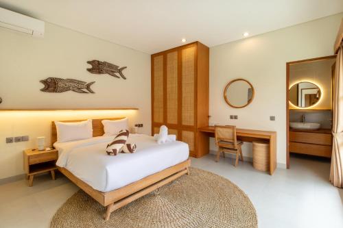 a bedroom with a bed and a desk and a mirror at Coco Luxury Villas in Ubud