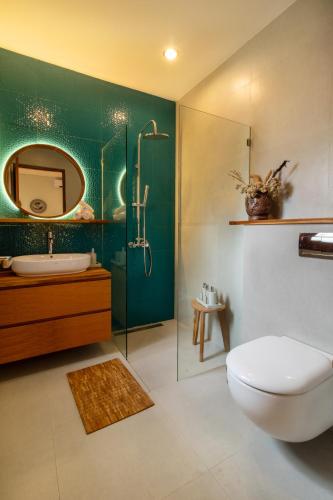 a bathroom with a toilet and a sink and a mirror at Coco Luxury Villas in Ubud
