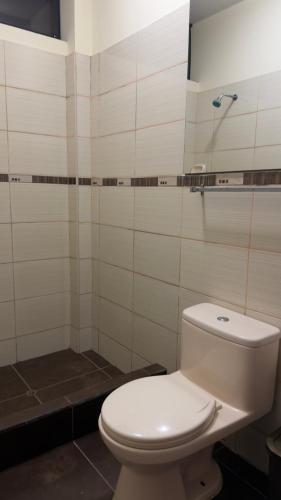 a bathroom with a white toilet and a shower at Hospedaje Maju Del Oriente in Pucallpa