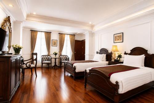 a hotel room with two beds and a television at Dhavara Boutique Hotel in Vientiane