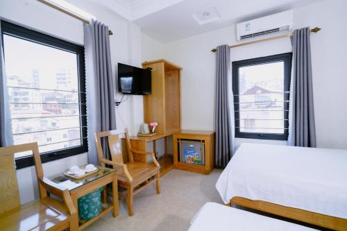 a hotel room with a bed and two windows at Tân Trang in Ha Long