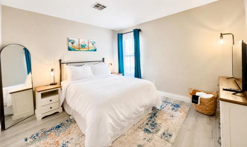 a white bedroom with a bed and a tv at No Added Fees! Craig Ranch HomeShare Retreat in Las Vegas