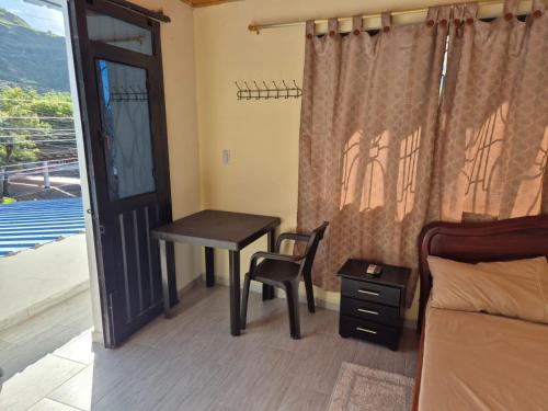 a bedroom with a desk and a table and a window at Brisas Alojamiento in Gualanday