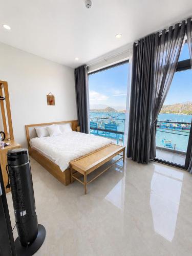 a bedroom with a bed and a large window at Đầm Nại Hotel in Ninh Hải
