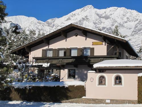 a house in the snow with mountains in the background at Appartement Isabella in Mieming