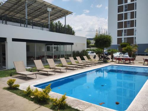 a swimming pool with lounge chairs and a building at Catalán Sant Andreu in Guadalajara