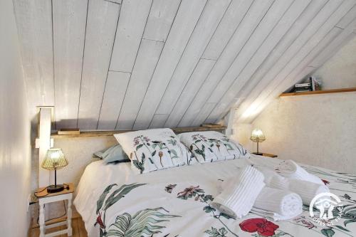 a bed in a room with a white ceiling at L'abri de la chouette in Langonnet