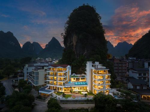 a view of a building with mountains in the background at Yulonghe Yushan Country Hotel in Yangshuo