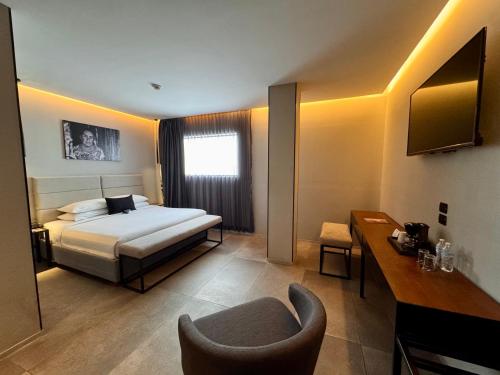 a hotel room with a bed and a chair at Ontico Urban Design Hotel in Mérida