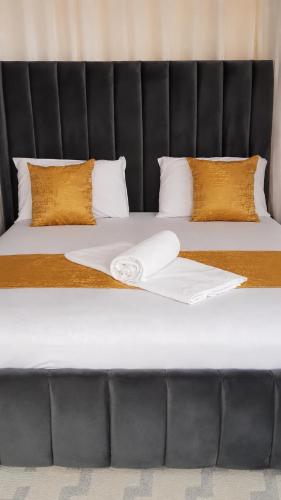 a bed with two white sheets and a black headboard at 1 bedroom apartment in shanzu near pride inn resort in Mombasa
