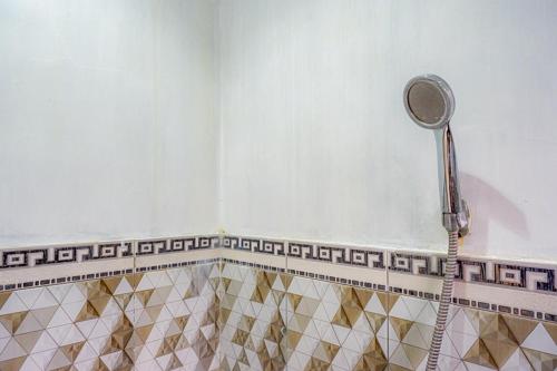 a shower with a shower head in a bathroom at RedDoorz @ Gerbang Dieng Plateau Area in Wonosobo