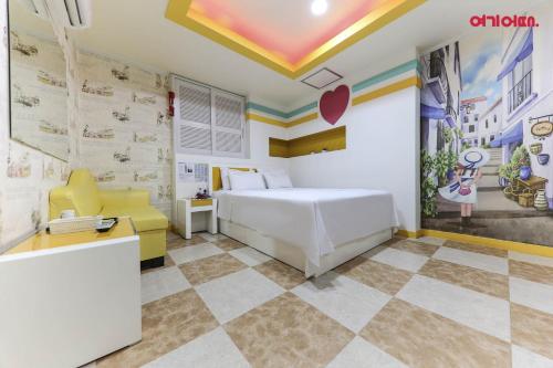 a bedroom with a white bed and a checkered floor at 호텔사랑 in Cheonan