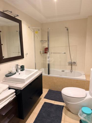 a bathroom with a sink and a toilet and a tub at Апартаменты в Вари in Vari