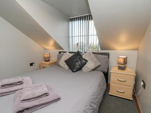 a bedroom with a bed with two night stands and two lamps at Fortunatus in Whitby