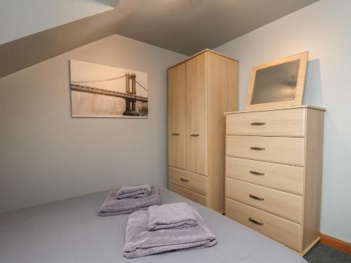 a bedroom with a bed and a dresser with towels at Fortunatus in Whitby