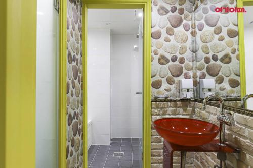 a bathroom with a red sink and a stone wall at 호텔사랑 in Cheonan