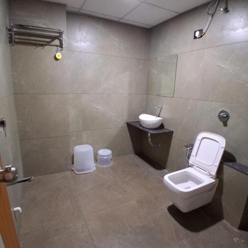 a bathroom with a toilet and a sink at Hotel Sun Park Vadodara in Vadodara