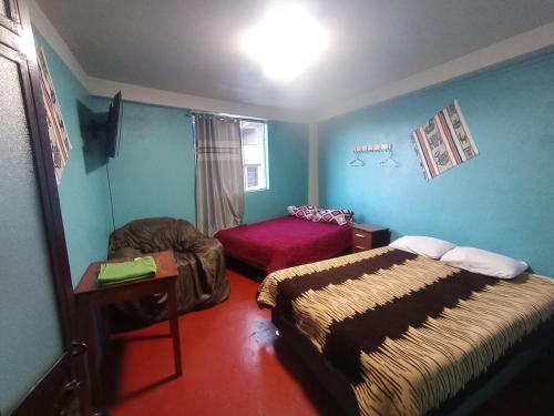 a room with two beds and a chair in it at Chepe de mi Corazon in Abancay