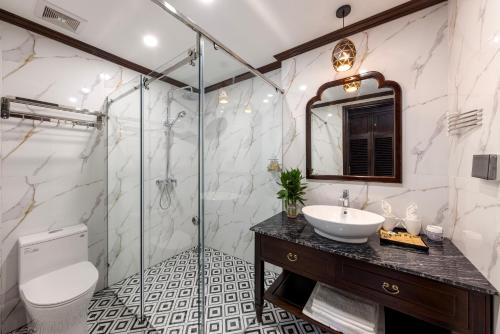 a bathroom with a shower and a sink and a toilet at Le Maison Tam Coc Boutique Hotel in Ninh Binh