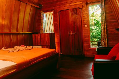 a bedroom with a bed in a wooden cabin at Banana Leaf Bungalow in Gili Trawangan