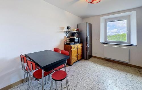 a kitchen with a table and a refrigerator and a window at Elegant Apprt in Lachamp-Raphaël