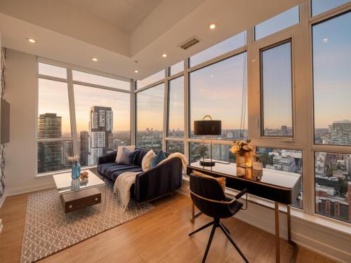 a living room with a large group of windows at VOGUE Suites Toronto in Toronto