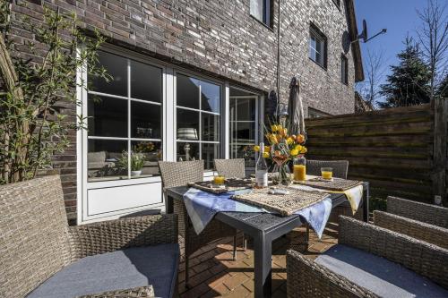 a patio with a table and chairs and a building at Ferienhaus Lillys Beachhouse in Varel