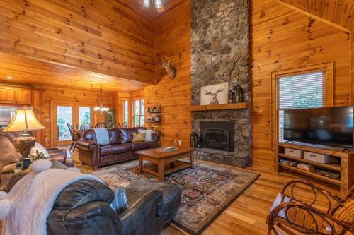 a living room with a stone fireplace in a log cabin at The Forge in Lansing