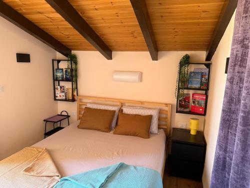 a bedroom with a bed in a room with wooden ceilings at Emanuela Chalets in Moshav Ramot