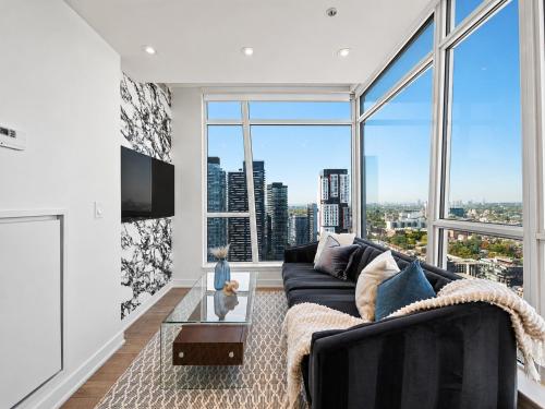 a living room with a couch and a large window at VOGUE Suites Toronto in Toronto