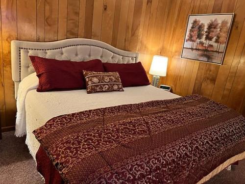a bedroom with a large bed with red pillows at Bambi Motel in East Tawas