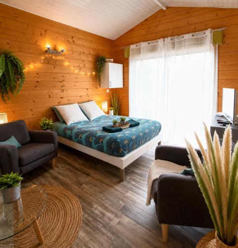 a bedroom with a bed in a room with wooden walls at Gîte 2 pers avec jardin entre Bordeaux & Lacanau Océan in Brach