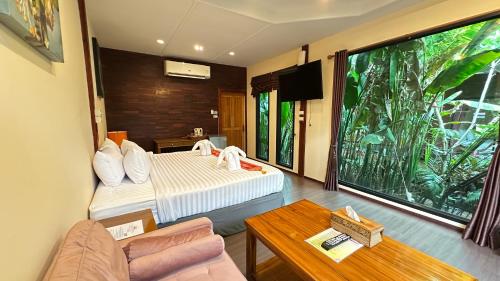 a room with a bed and a couch and a window at 88 Homestay in Bang Chak