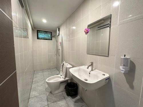 a white bathroom with a toilet and a sink at 88 Homestay in Bang Chak