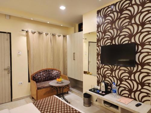 a living room with a tv on a wall at The White Orchid Dalhousie in Dalhousie