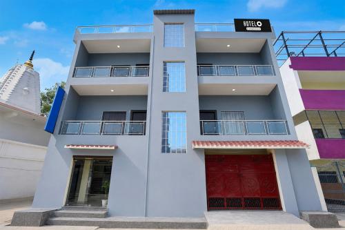 a white building with red doors in front at Super Hotel O Kashi Ghat Varanasi Formerly Ganga Valley in Rāmnagar