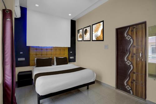 a bedroom with a bed and two pictures on the wall at Super Hotel O Kashi Ghat Varanasi Formerly Ganga Valley in Rāmnagar