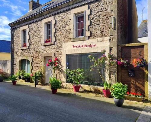 a brick building with potted plants on the street at Breizh & Breakfast in Rosporden