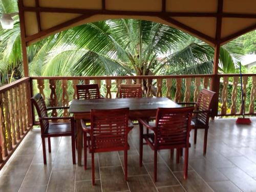a wooden table and chairs on a deck with a palm tree at Suites Chile Verde in Manzanillo