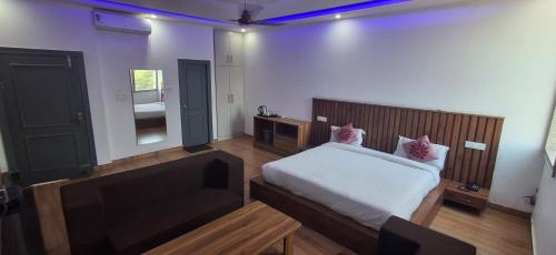 a bedroom with a bed with white sheets and pink pillows at Hotel Parth Inn in Haldwāni