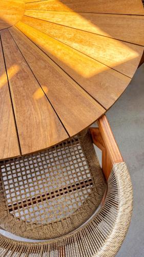 a wooden table with a wicker chair under it at Thea Syros in Ermoupoli