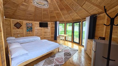 a bedroom with a bed in a wooden cabin at Близняшки in Kaji-Say