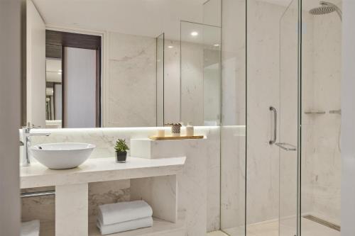 a bathroom with a sink and a glass shower at Hyatt Centric Gran Via Madrid in Madrid