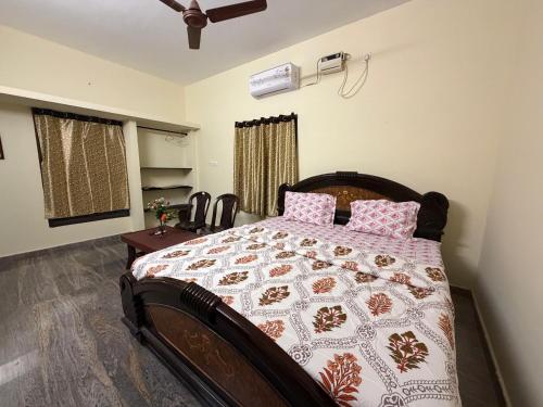 a bedroom with a large bed with pink pillows at Serinity Saral in Pondicherry