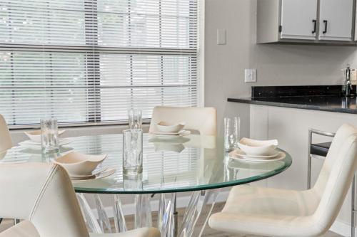 a dining room with a glass table and white chairs at Green Mountain Getaway 2BDR in Branson