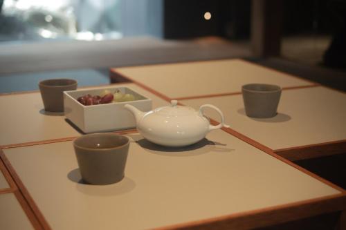 a tea pot and cups sitting on a table at MU HEN KO Q -Nara- in Nara