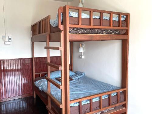 a bunk bedded room with two bunk beds in a room at The Kanee Hostel in Nakhon Phanom