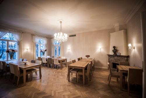 a dining room with tables and chairs and a chandelier at Mukkulan kartano in Lahti