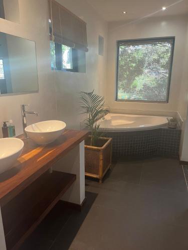 a bathroom with two sinks and a bath tub at Private Retreat in Gordonʼs Bay